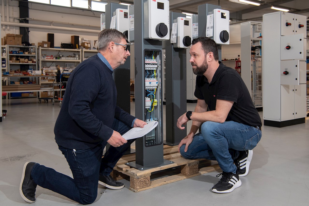 Indehaver Bjarne Rasmussen (tv) fra X-EL Tavler og Rasmus Eksten fra ABB ved en Terra AC-lader. For at gøre installatørens arbejde hurtigere og nemmere er RCD-fejlstrømsafbrydere og MCB-automatsikringer indbygget i standeren i stedet for i kundens hovedtavle.