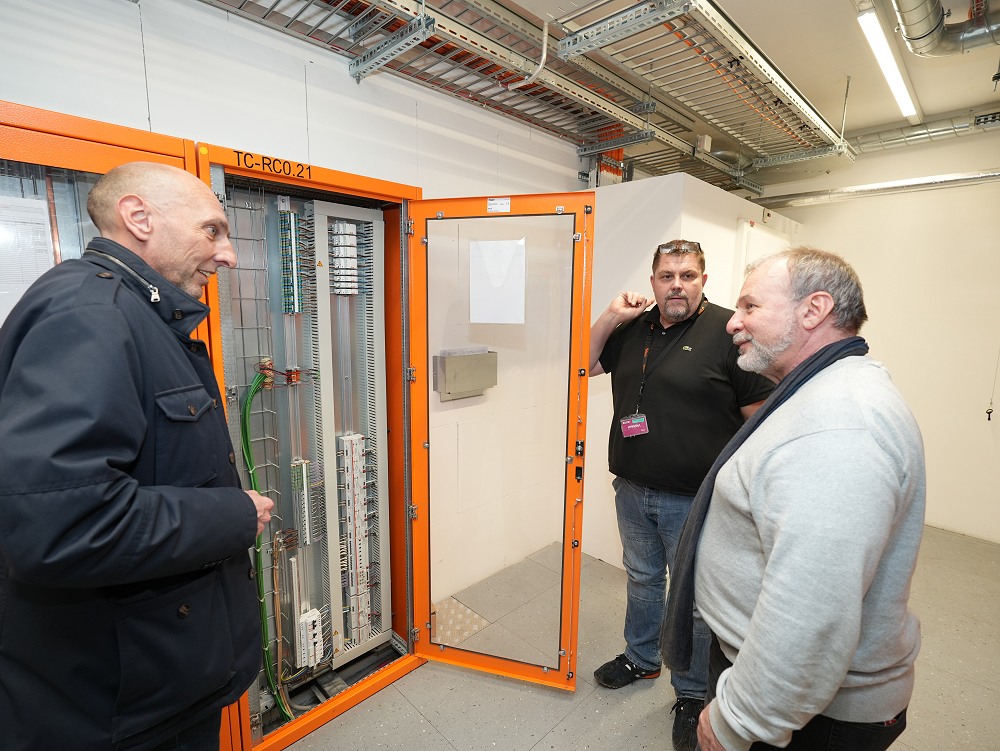 Alexandre Coendoz, zuständiger Verkaufsingenieur von ABB Schweiz, mit Sébastien Mouthon (Groupe E) und François Filet (tpg) bei einem Schrank mit KNX-Installationsgeräten im neuen Depot. (v.l.n.r.)
