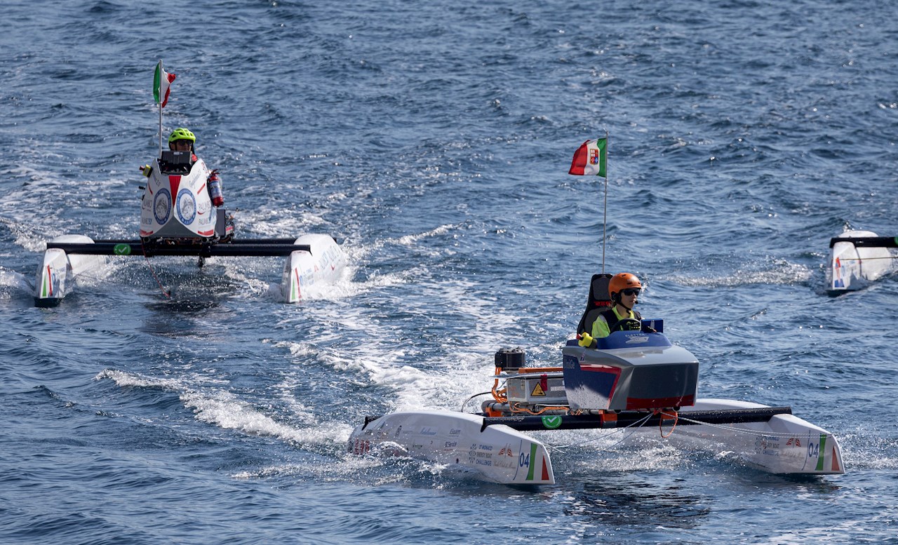 Il catamarano elettrico guidato dalla pilota di Elettra, Camilla Margherita Poggi, studentessa di ingegneria navale. Sullo sfondo, il team italiano dell’Università di Messina